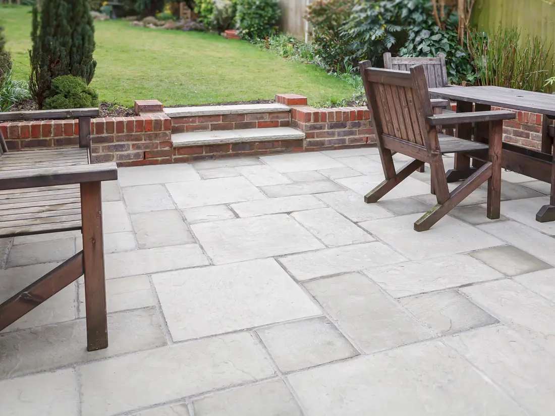 A natural stone patio and lawn laid by Merseyside Driveways