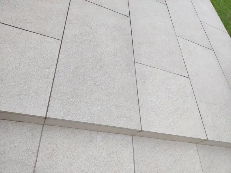 Large-format pale grey porcelain paving with crisp, even joints